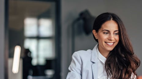 Advogada feliz enquanto estuda inglês com as aulas do Berlitz.