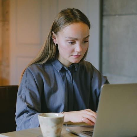 Mulher com seu computador estudando idiomas de forma online.