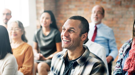 Homem sorrindo durante uma apresentação.