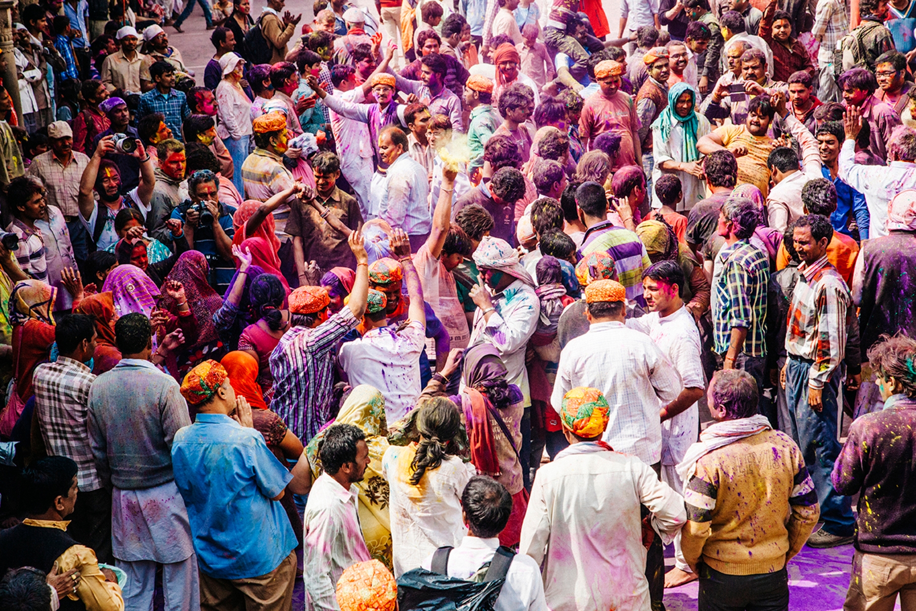 Aglomeração de indianos desfrutando de um dos principais festivais no mundo com guerra de tinta.