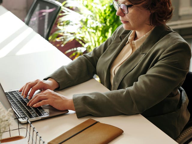 Mulher estuda inglês autodidata pela internet com rotina flexível.