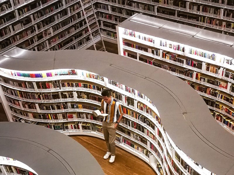 Homem lê livro com palavras em alemão em livraria