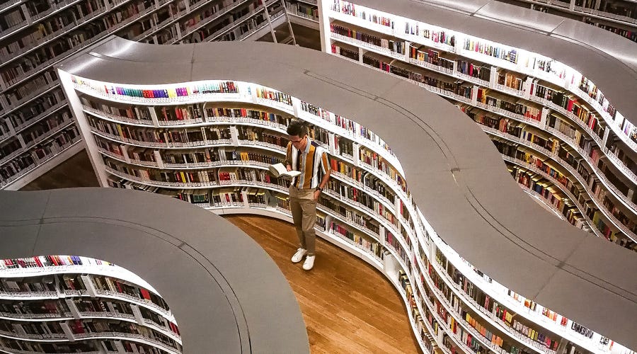 Homem lê livro com palavras em alemão em livraria