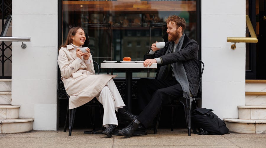 Um homem e uma mulher tomando algo em uma cafeteria da Itália.
