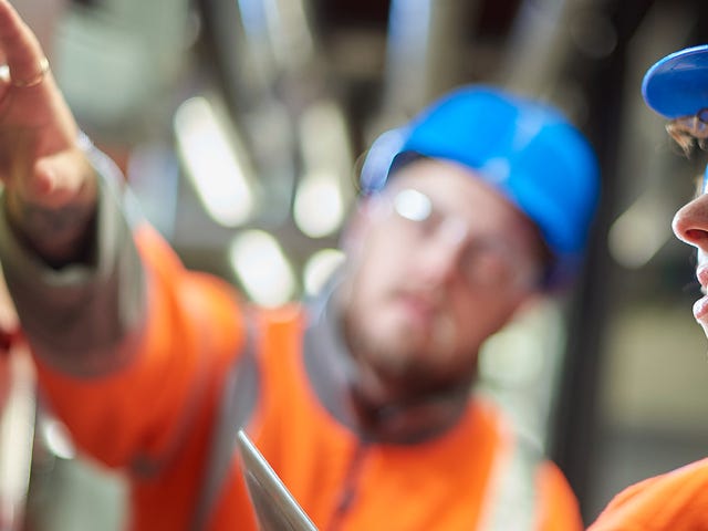 Colegas de trabalho avaliando os equipamentos após aprenderem termos da logística em inglês.