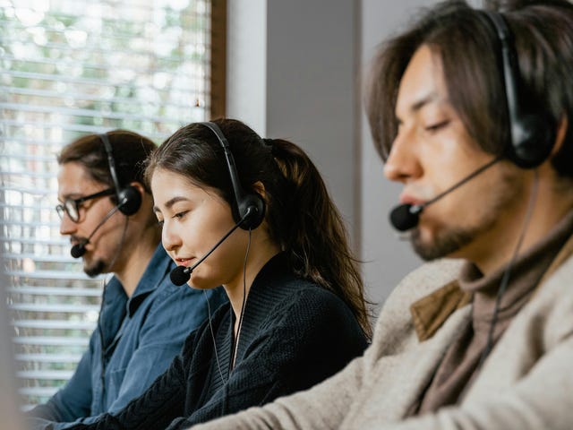 Uma mulher e dois homens trabalhando com atendimento ao cliente, usando fones de ouvido e computadores para ganhar produtividade digital.
