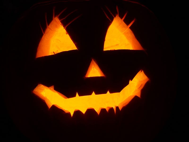 Abóbora personalizada com um rosto e uma luz dentro da abóbora ressaltando o desenho. Conheça a origem do Halloween.