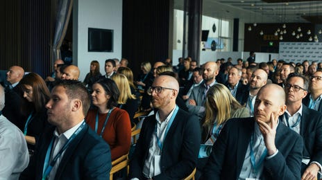 Vários colaboradores estão sentados escutando uma palestra sobre adaptabilidade, uma soft skill útil para negócios.