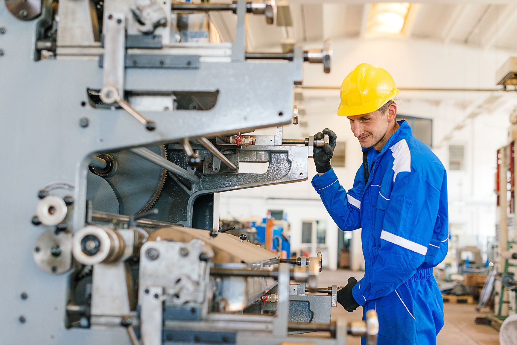 Homem operando máquina com mais segurança após entender o manual de instruções com o inglês técnico mecânica industrial.