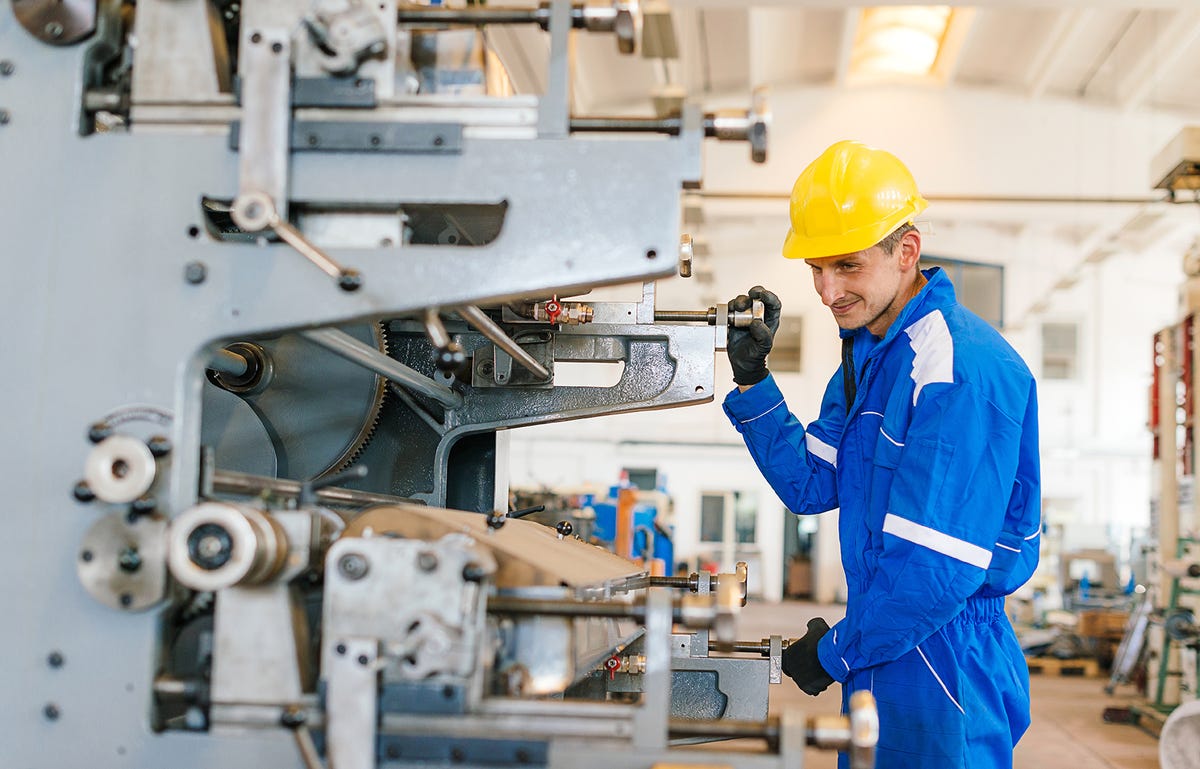 Homem operando máquina com mais segurança após entender o manual de instruções com o inglês técnico mecânica industrial.