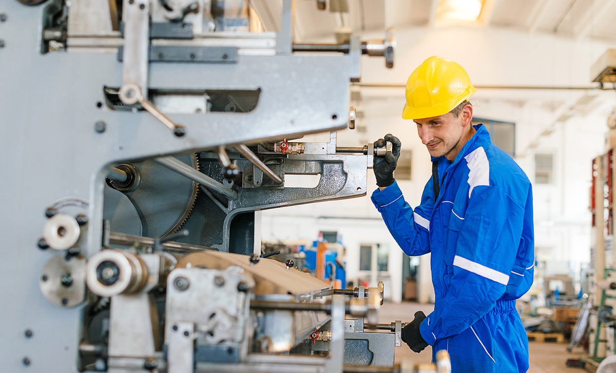 Homem operando máquina com mais segurança após entender o manual de instruções com o inglês técnico mecânica industrial.
