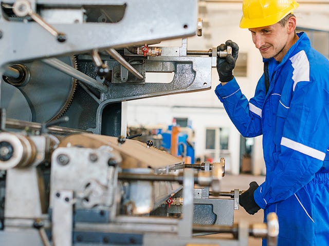 Homem operando máquina com mais segurança após entender o manual de instruções com o inglês técnico mecânica industrial.