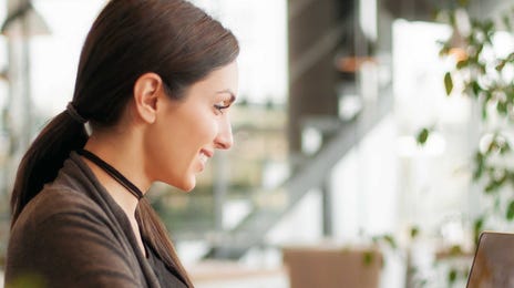 Mulher empresária trabalhando em um computador após estudar inglês.