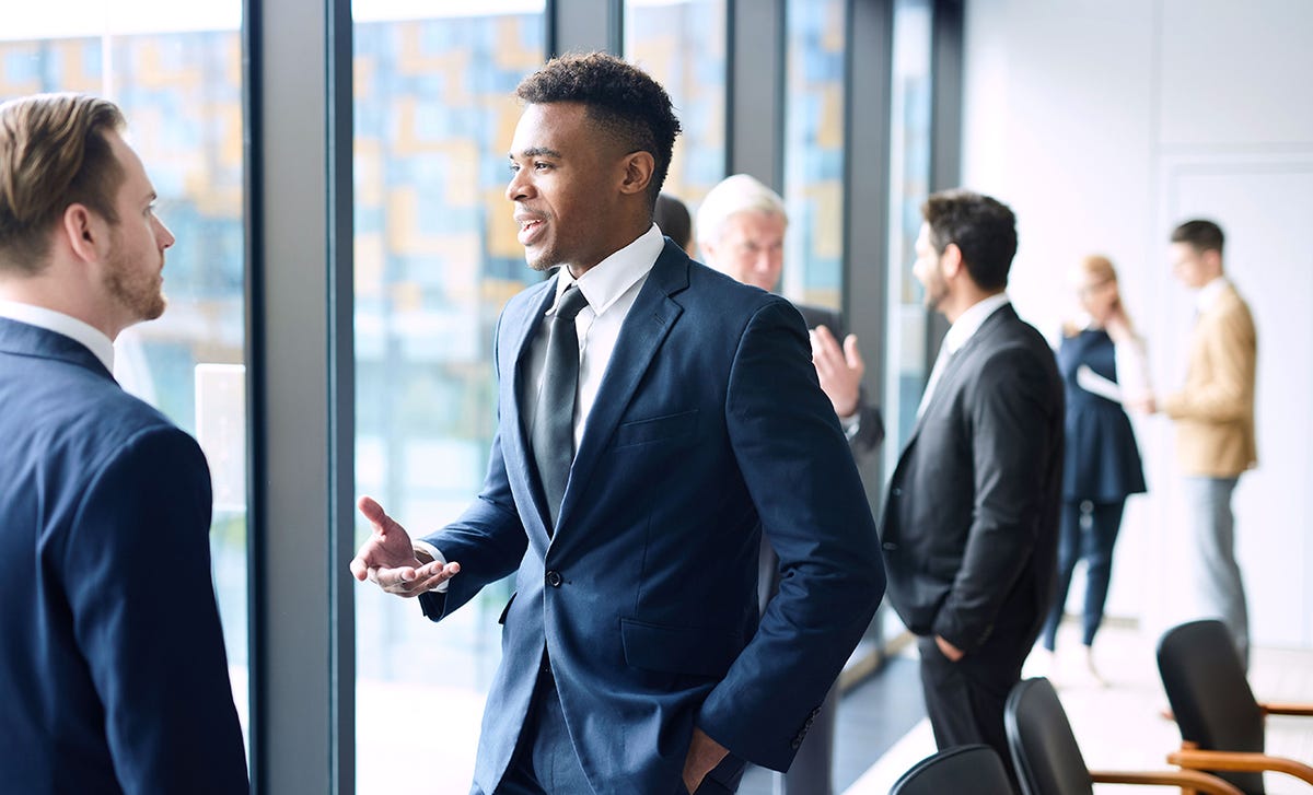 Advogados conversando animadamente sobre as aulas de inglês jurídico.