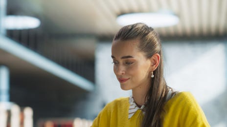 Mulher estudando para exames de preparação de idiomas com um notebook.