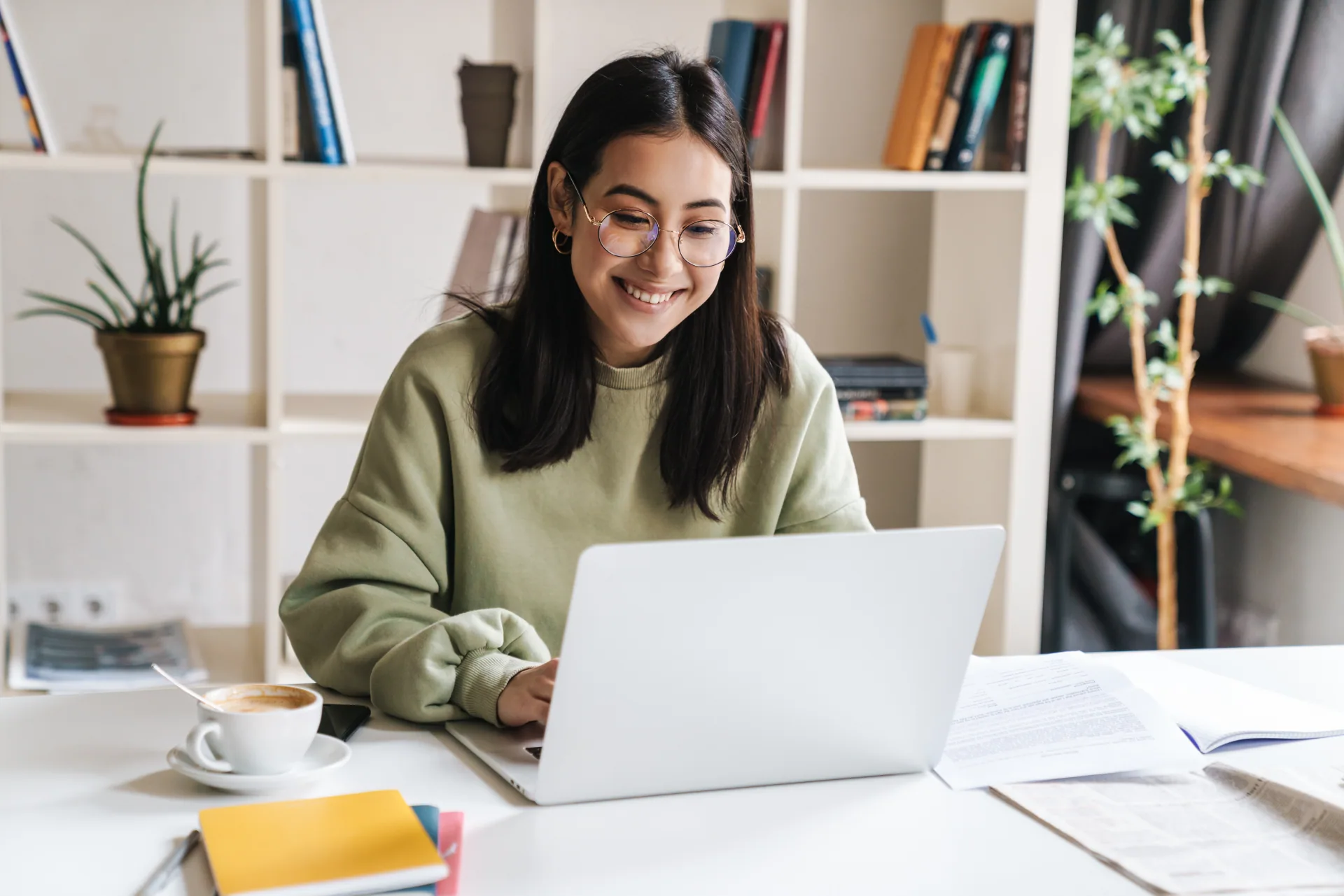Mulher sentada frente ao laptop, estudando para exames de proficiência em inglês