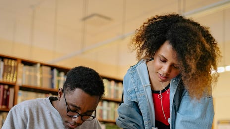 Dois estudantes fazendo uma pesquisa na biblioteca  para a aula de japonês no Rio.