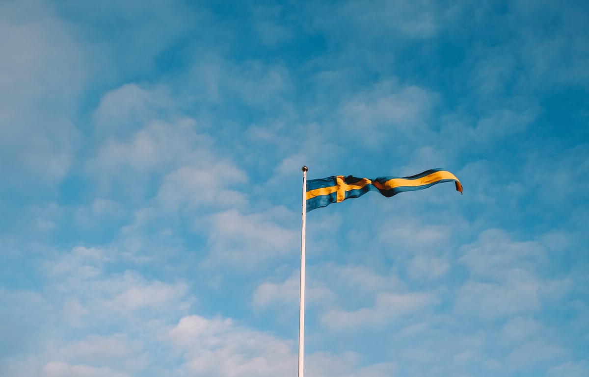 bandeira da Suécia no meio de um céu azul com nuvens