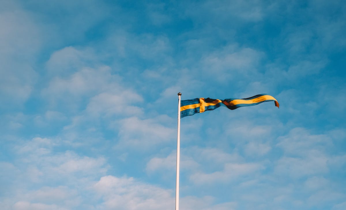 bandeira da Suécia no meio de um céu azul com nuvens