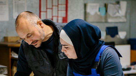 Dois colegas de trabalho analisando uma planta de um maquinário para o setor de mecânica industrial.
