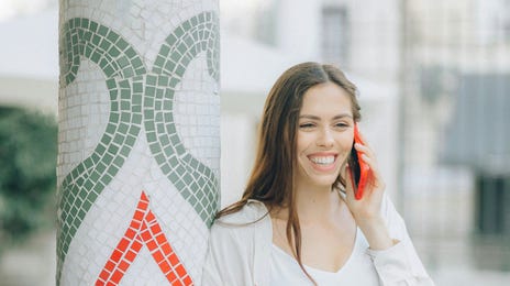 Mulher faz aulas de italiano online com alegria pelo telefone.