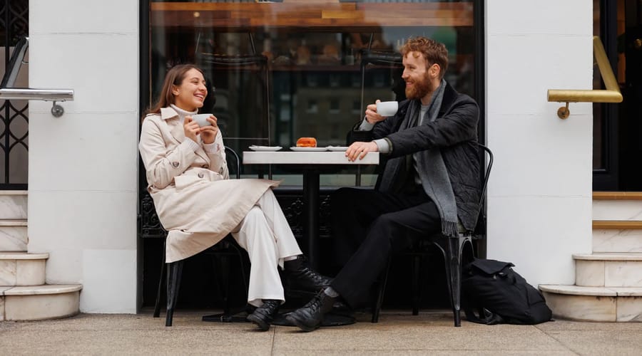 Homem e mulher sentados em uma mesa conversando sobre a cultura hispânica.