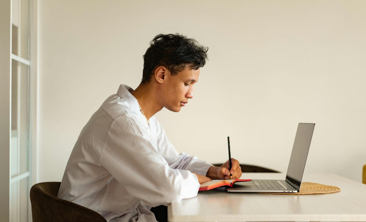 Homem escrevendo em seu diário sobre o teste Telc C2.