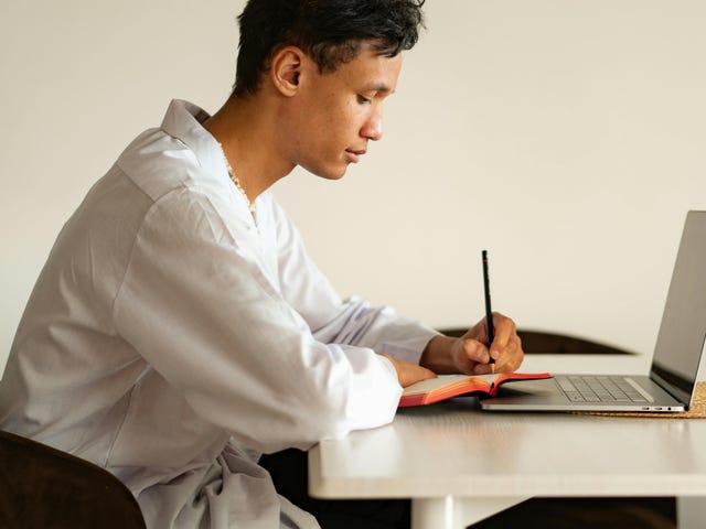 Homem escrevendo em seu diário sobre o teste Telc C2.