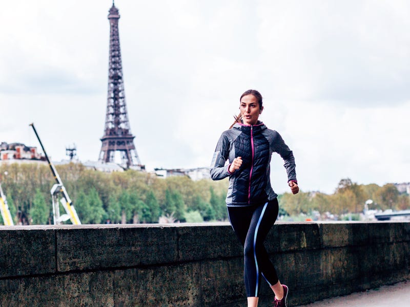 Mulher corre em frente à Torre Eiffel preocupada com o tempo em francês.
