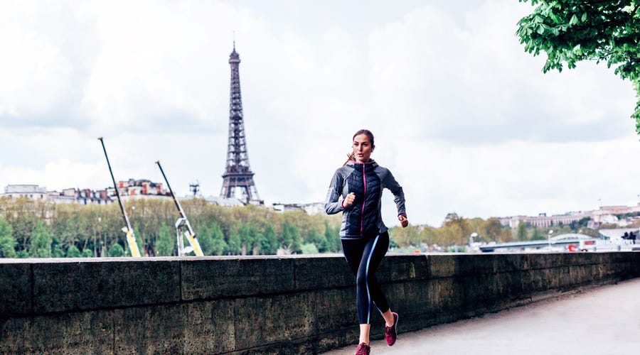 Mulher corre em frente à Torre Eiffel preocupada com o tempo em francês.