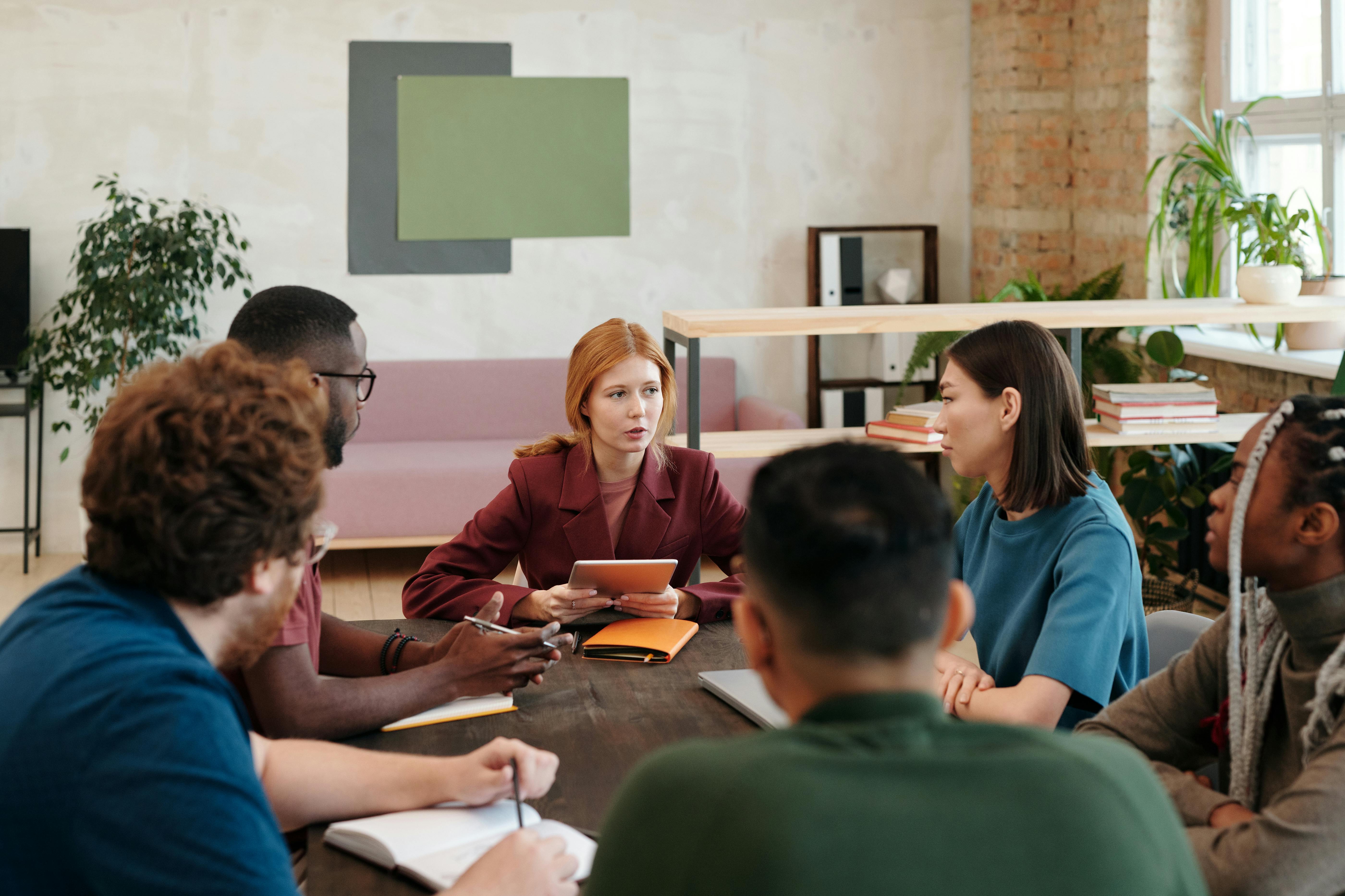 Time reunido em volta de uma mesa de reunião para discutir inteligência emocional no trabalho.