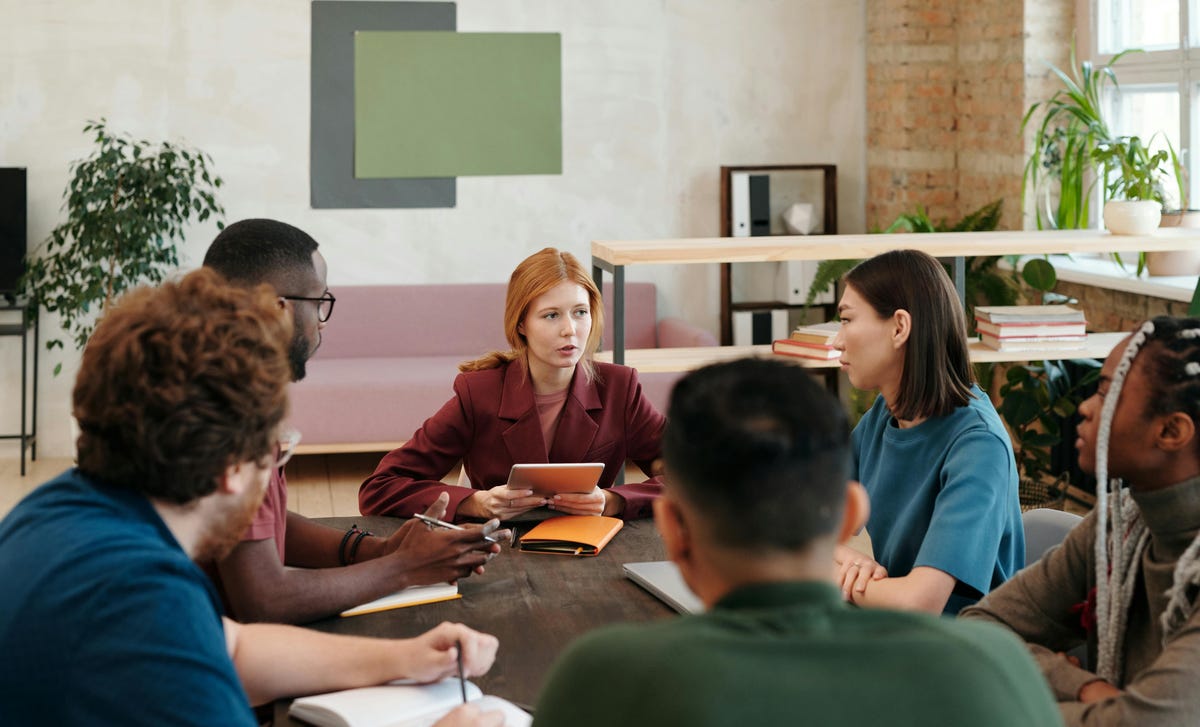 Time reunido em volta de uma mesa de reunião para discutir inteligência emocional no trabalho.