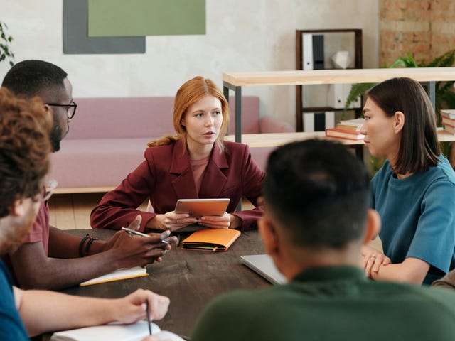Time reunido em volta de uma mesa de reunião para discutir inteligência emocional no trabalho.