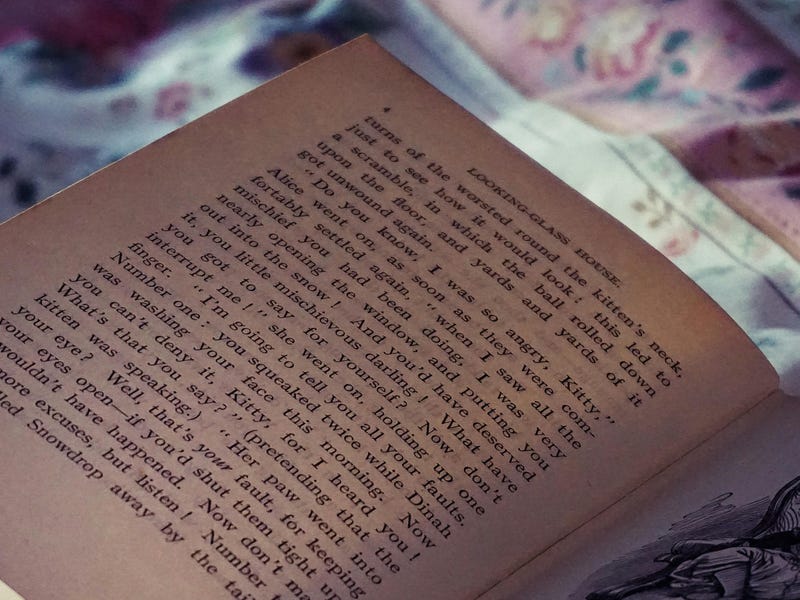 Livro com fábulas em inglês e figuras aberto sobre a cama.