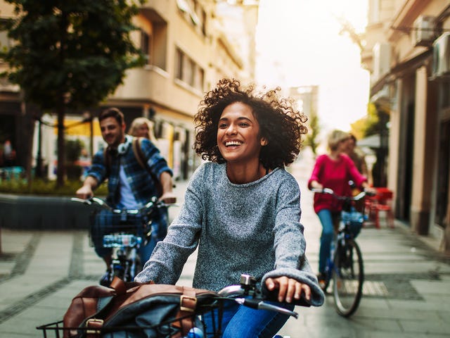 Jovens do intercâmbio de espanhol se divertindo enquanto andam de bicicleta por Barcelona.