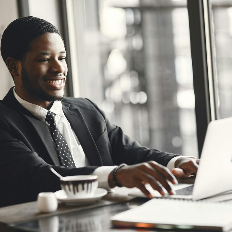 Homem redigindo um e-mail em inglês no trabalho.