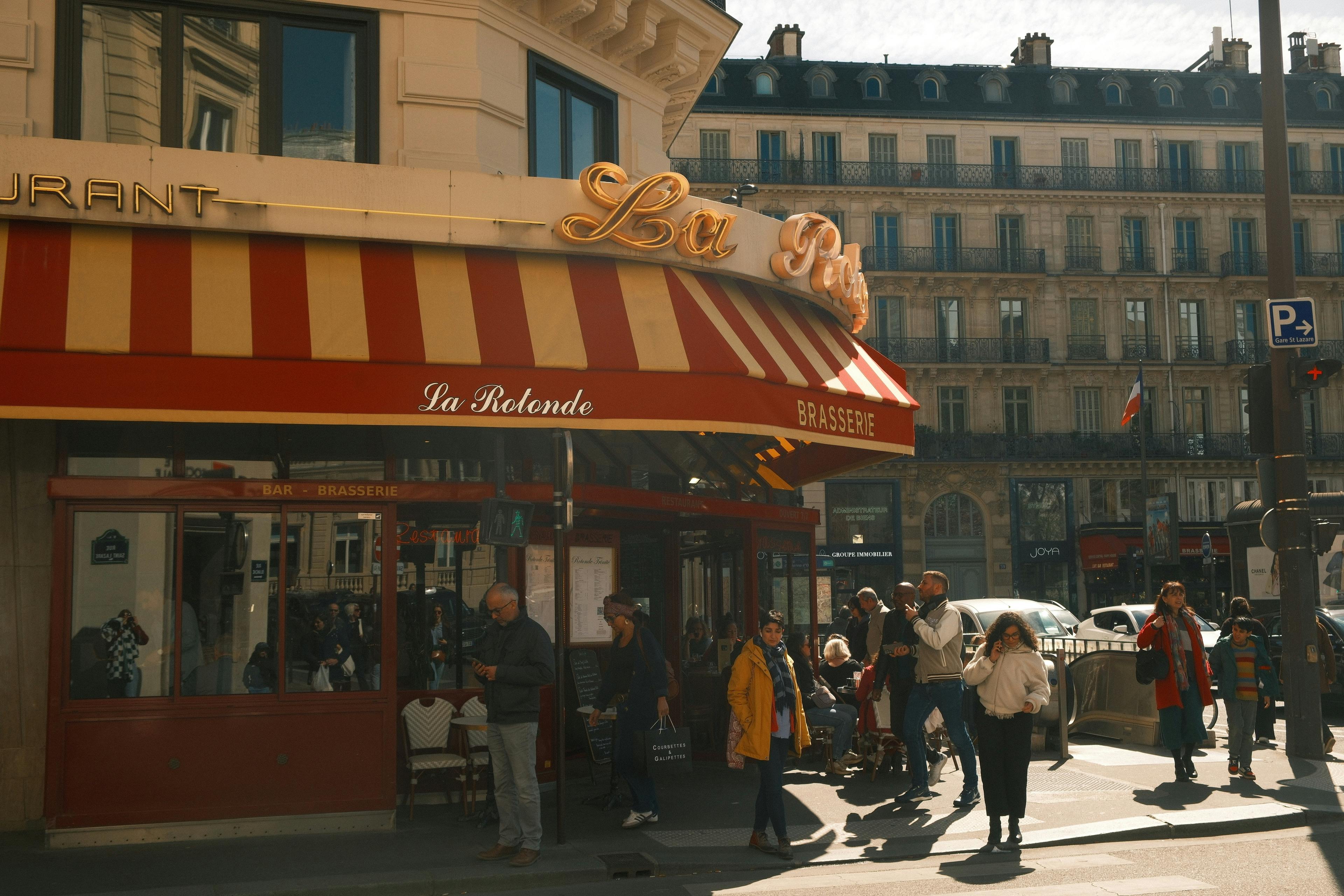 Fachada de um restaurante com pessoas na rua para representar os costumes da França.