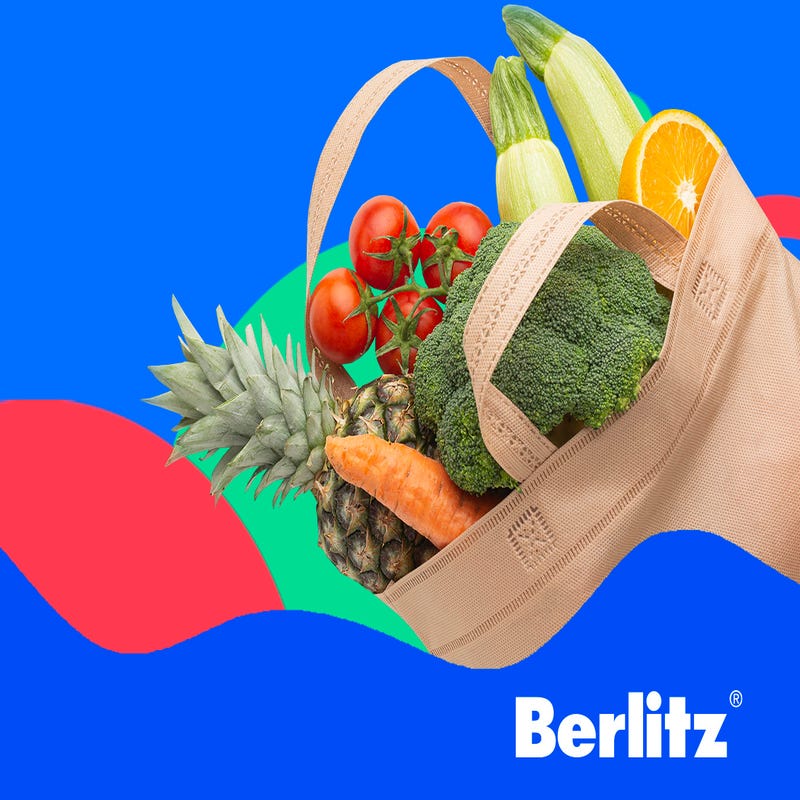 Sacola de mercado que traz comidas em inglês com abacaxi, tomates, brócolis, cenoura e outros alimentos.