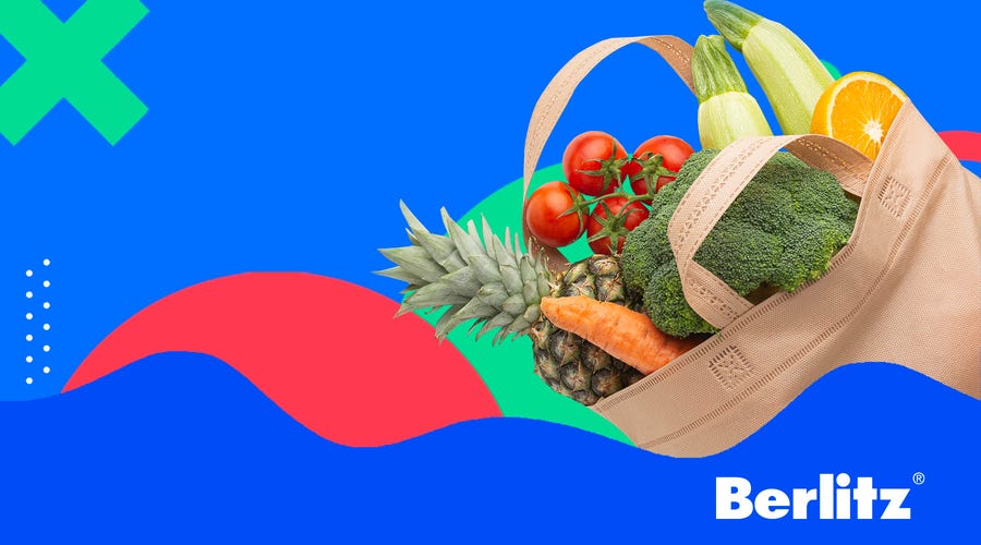 Sacola de mercado que traz comidas em inglês com abacaxi, tomates, brócolis, cenoura e outros alimentos.