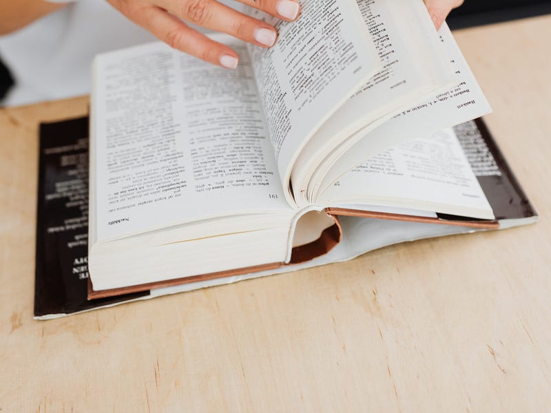 Mulher pesquisa no dicionário palavras em inglês sem tradução