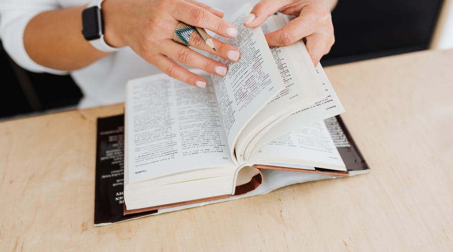 Mulher pesquisa no dicionário palavras em inglês sem tradução