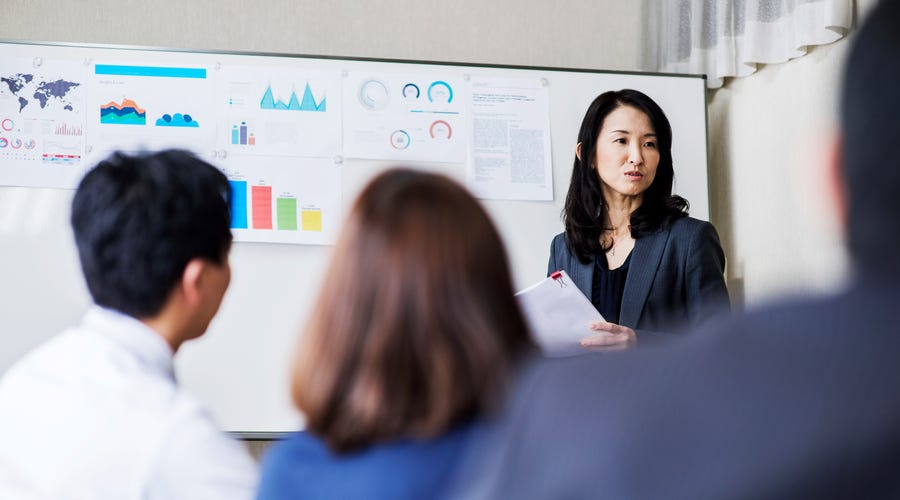 Mulher apresenta um planejamento estratégico para a sua equipe na empresa