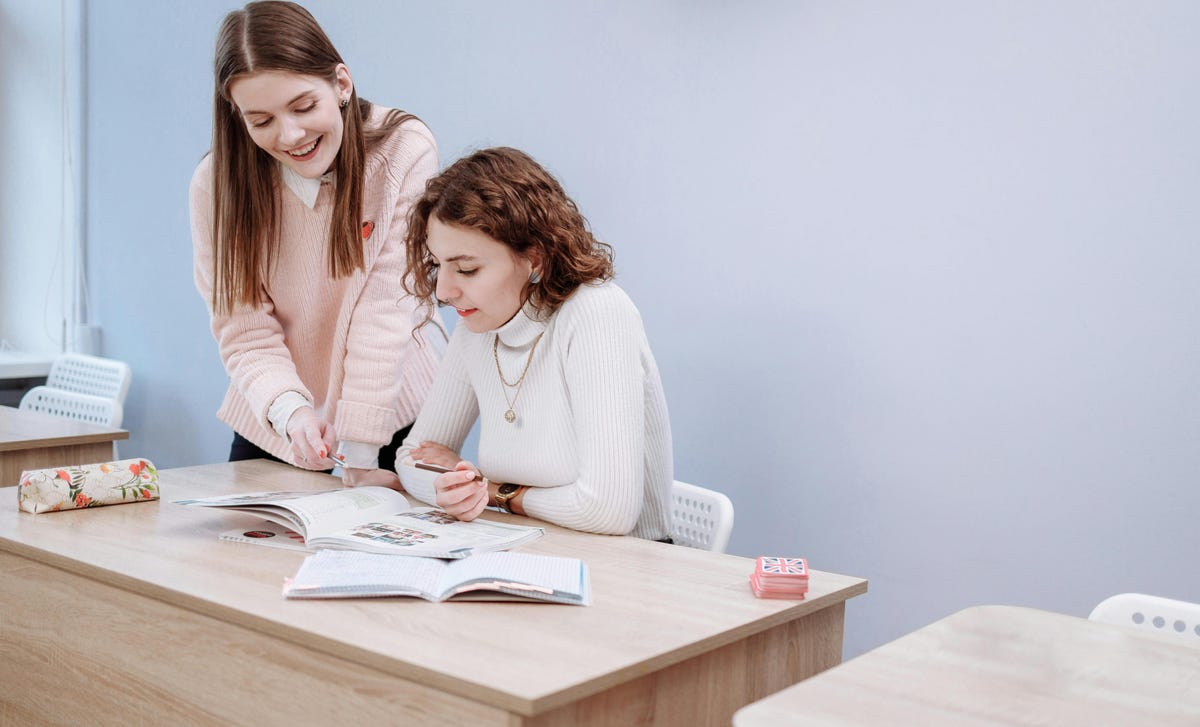 Jovem faz aula particular de idiomas com instrutora no Berlitz.