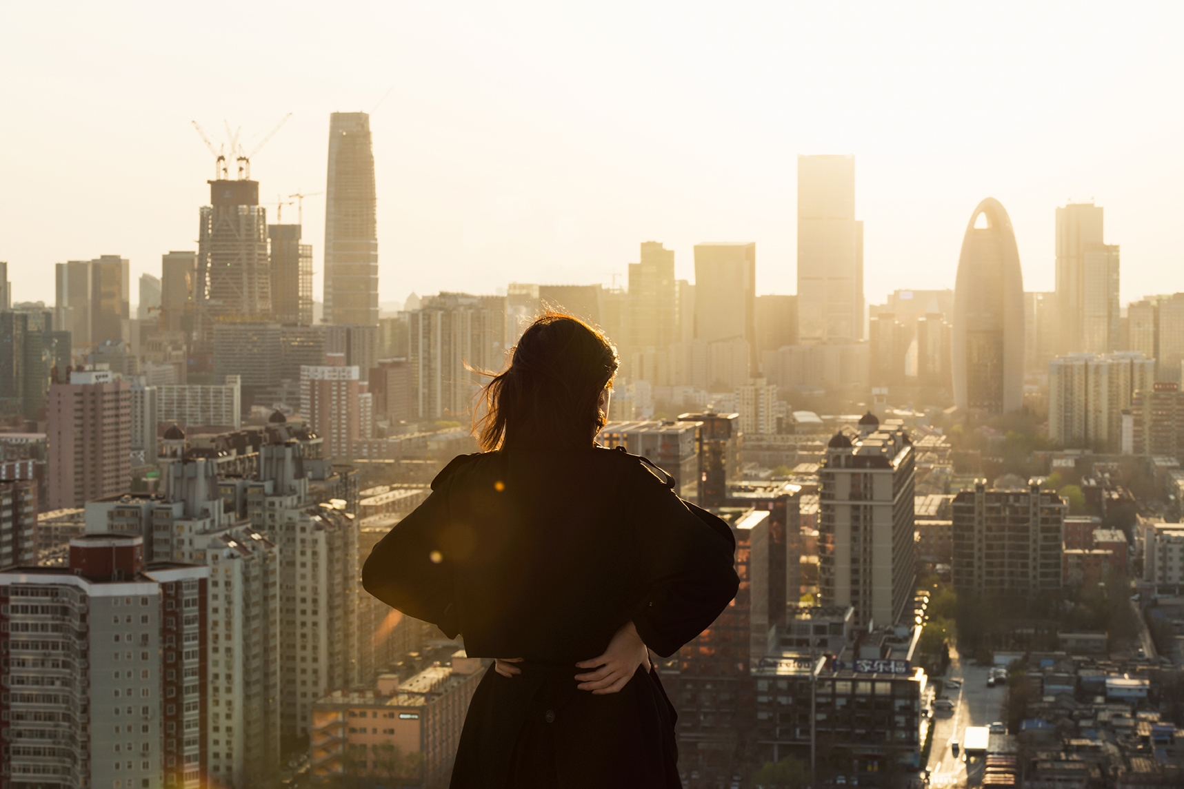 Mulher no topo de um prédio, apreciando a vista da cidade, em um dos melhores países para fazer intercâmbio.