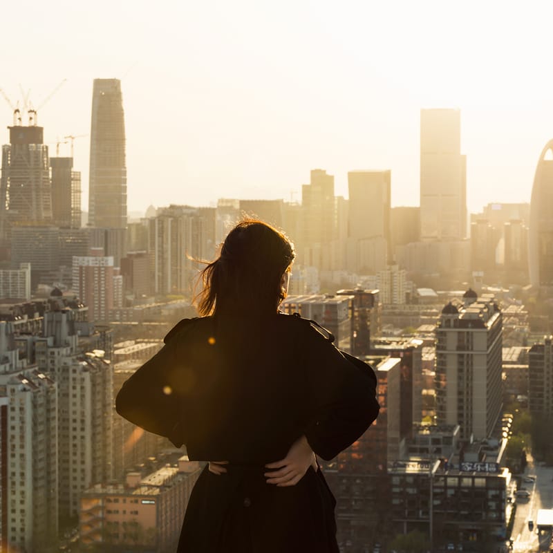 Mulher no topo de um prédio, apreciando a vista da cidade, em um dos melhores países para fazer intercâmbio.