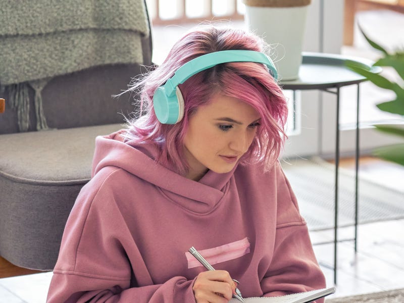 Mulher de cabelo rosa realizando uma lição de francês online.