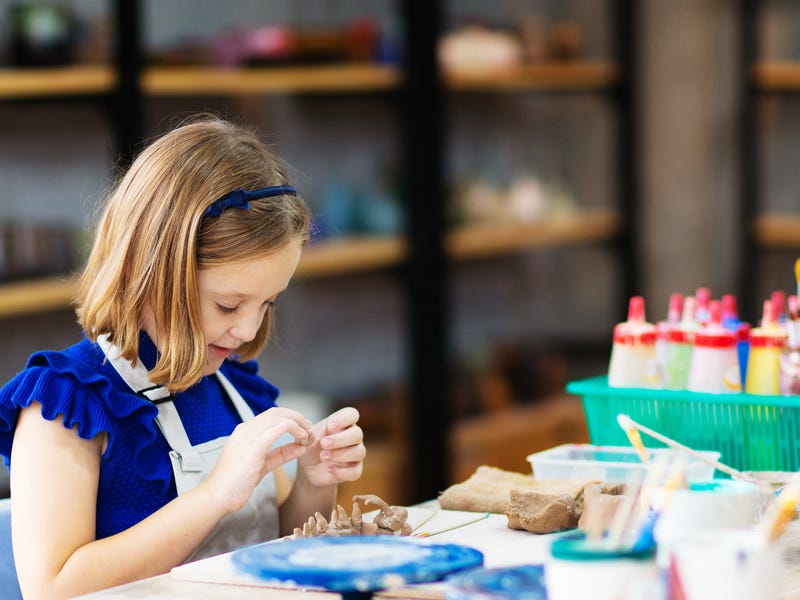 Criança faz trabalhos manuais em sala de aula
