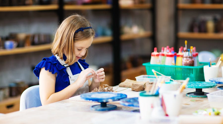 Criança faz trabalhos manuais em sala de aula