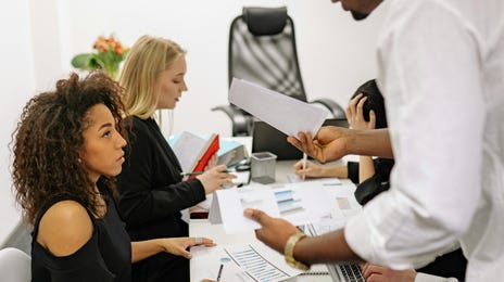 Homem discutindo com colaboradora durante reunião pois não sabe como fazer a gestão de conflitos em sua empresa.