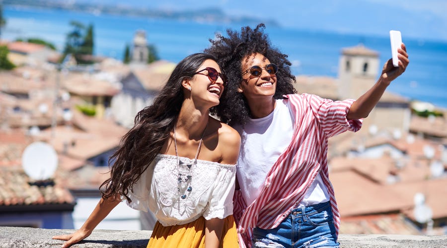 Jovens tiram fotos juntas em um dos pontos turísticos mais conhecidos do mundo